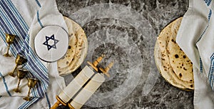 Orthodox Jewish family symbols with cup wine kosher matzah on traditional jewish passover holiday Scrolls torah