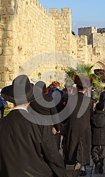 Orthodox Jews walking along the city wall of Jerusalem towards Jaffa Gate