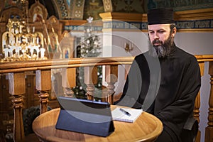 . An Orthodox priest is recording a video for his blog. Preaching during a pandemic