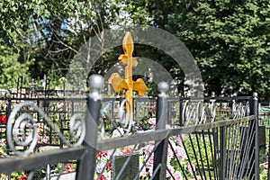 Orthodox wooden cross on a grave in a Christian cemetery in summer vegetation. Memory and sorrow