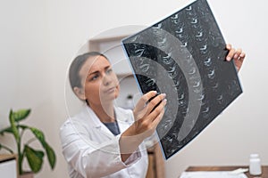 Orthopedic Diagnosis: doctor uses a laptop to assess patient X-ray films and MRI scans at a table.