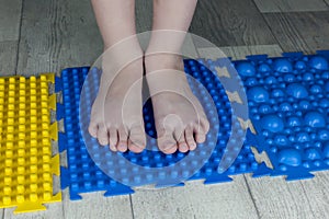 Orthopedic foot mat for child gymnastic. Small children with a flat-bottomed stomach goes barefoot on an orthopedic