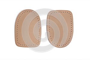 Orthopedic leather heel pad from corns for the correction of different lengths of legs isolated on white background.