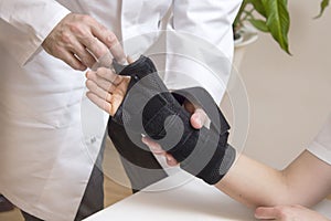 Orthopedic surgeon assumes a stabilizer for the woman`s hand.