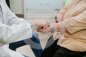 Orthopedic surgeon examining the knee reflex. The doctor checks the physiological reflex, the test hammer