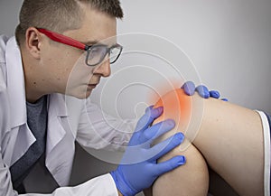 An orthopedist examines the knee of a patient who complains of acute pain. Diagnostics and treatment of cartilage tissue diseases