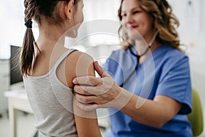 Orthopedist examines the spine, posture, and spinal deformities of little girl. Girl visiting paediatrician for annual