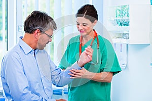 Orthopedist examining hand of patient in surgery photo