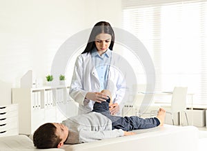 Orthopedist examining little patient`s leg in clinic