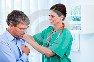 Orthopedist examining shoulder of patient in surgery