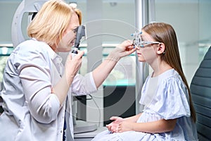 Orthoptist performing dynamic retinoscopy on little girl photo