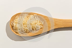 Parboiled Chinese Rice seed. Nutritious grains on a wooden spoon photo