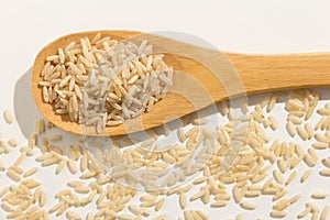 Whole Chinese Rice seed. Healthy grains on a wooden spoon. Whit photo