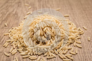 Whole Chinese Rice seed. Pile of grains on the wooden table. Selective focus. photo