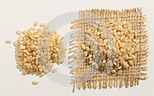 Whole Short Grain Rice Seed. Close up of grains spreaded over white table. photo