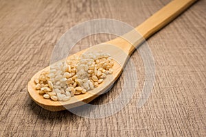 Whole Short Grain Rice Seed. Spoon and grains over wooden table. photo