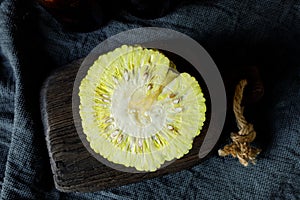 Osage Oranges Maclura pomifera on an old chopping board. ut in half. Maclura use in alternative medicine