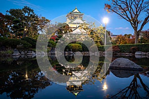 Osaka Castle with Japanese garden and reflection in pond at autumn season at night in Osaka, Japan. Japan tourism, history