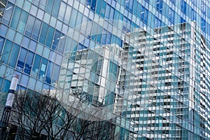 city buildings and blue sky reflection on glass office building windows