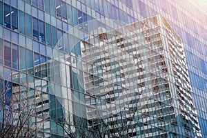Closeup and crop reflection of buildings and bright blue sky on glass office building windows