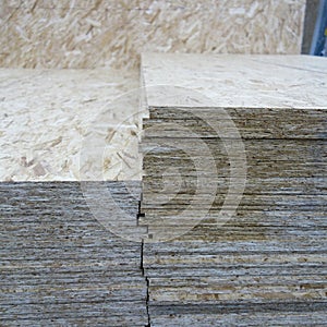 OSB background, dense, seamless surface. OSB sheets are stacked in a hardware store. Building material made from brown chips,