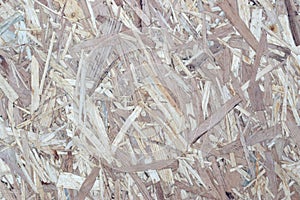 OSB boards made of brown wood chips sanded into a wooden background. Top view of OSB wood veneer background surface