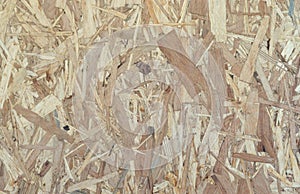 OSB boards made of brown wood chips sanded into a wooden background. Top view of OSB wood veneer background surface