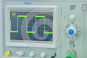 Oscilloscope with green wave on the display