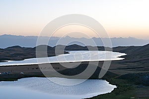 Morning Sunlight Landscape of Tulpar Kol Lake in Alay Valley, Osh, Kyrgyzstan. photo