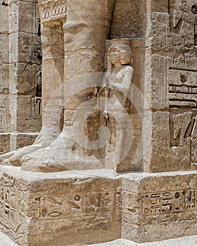 Osiride statue of Ramesses III being attended to by little queens on the right side of the first court of his Mortuary Temple. photo