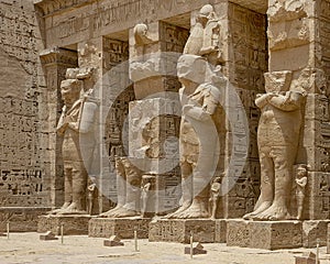 Osiride statues of Ramesses III being attended to by little queens on the right side of the first court of his Mortuary Temple. photo