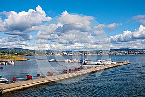 Oslo, Ostlandet / Norway - 2019/09/02: Panoramic view of Lindoya island marina on Oslofjord harbor with metropolitan Oslo, Norway