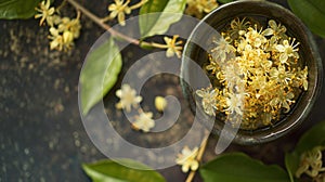 Osmanthus Tea in the cup with flowers inside and on the table.