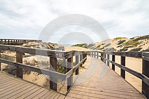 Wooden boardwalk through sand dunes. Oceano, California photo