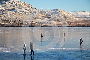 Osoyoos, British Columbia, Canada - December 31, 2021: Skaters on a frozen lake in winter