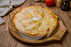 Ossetian pie with cheese on wooden table