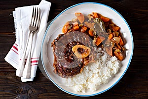 Osso buco beef stew with boiled rice in tomato sauce with onions, carrots, celery, garlic, rosemary and laurel leaves.