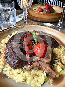 Osso Buco, Veal Shanks that are Braised in Wine with Saffron Risotto, Roasted Red Pepper and Rosemary.