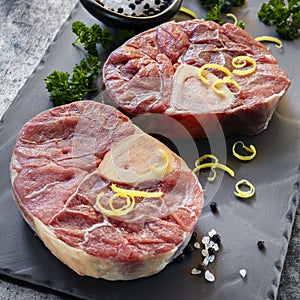 Osso Buco Veal Shanks Raw on Slate with Parsley and Lemon Zest photo