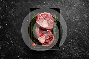 Osso buco Veal steak with rosemary and spices. On a black background.