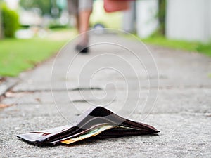 Ost leather wallet with money drop on sidewalk