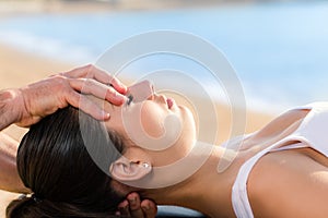 Osteopath doing cranial manipulation on woman outdoors.