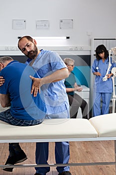 Osteopathic nurse stretching spinal cord and shoulder