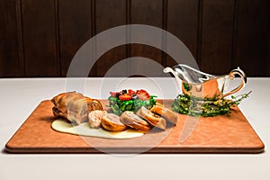 Osteria art of suckling pig porchetta on wooden cutting board photo