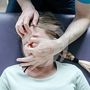 Ostheopatic treatment of a girl patient using CST gentle hands-on technique, central nervous system tension relieve