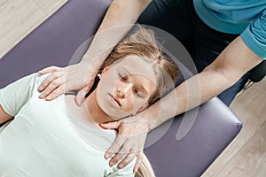 Ostheopatic treatment of a girl patient using CST gentle hands-on technique, central nervous system tension relieve