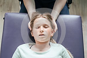 Ostheopatic treatment of a girl patient using CST gentle hands-on technique, central nervous system tension relieve