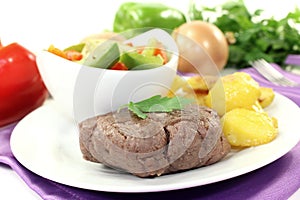 Ostrich steaks with baked potatoes and parsley