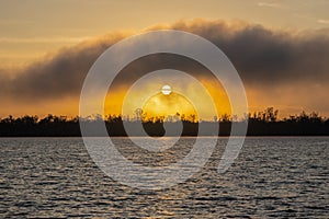 An other worldly sunrise over a lake and silhouetted trees