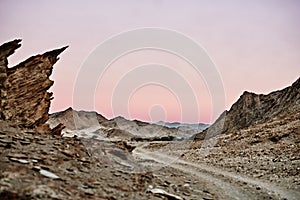 Through an otherworldly landscape. Shot of a dirt road running through rugged terrain.